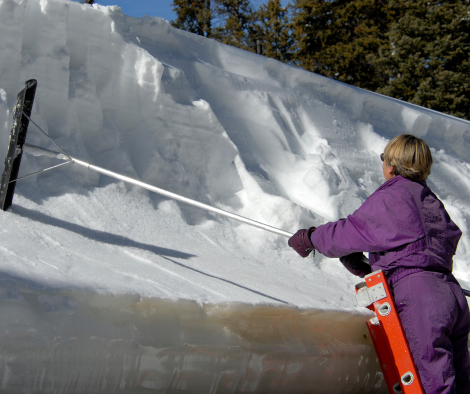 Woman using a roof rake to prevent ice dams